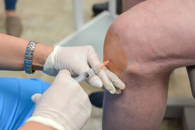 Doctor doing the Hyaluronic Acid knee Injections
