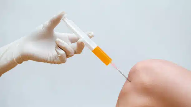 Doctor injecting a prp treatment on a patients knee
