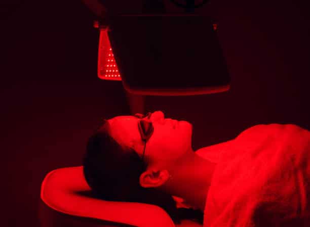 woman on a bed getting red light therapy