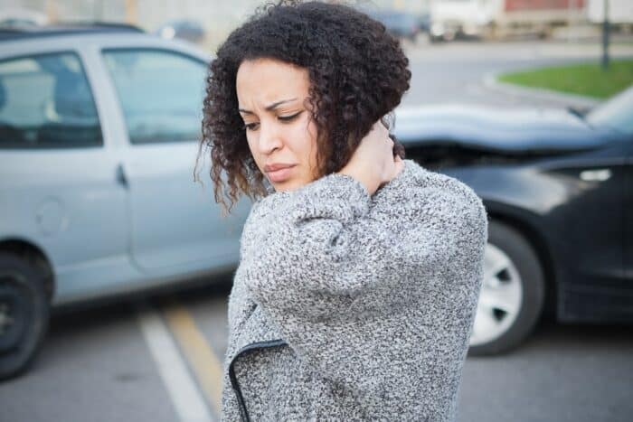 woman holding her neck in pain from a car accident