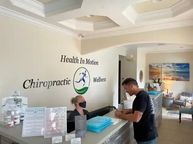 patient and frontdesk woman in the lobby of a chiropractic center