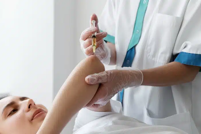 High angle view of a woman receiving Platelet Rich Plasma injection her elbow