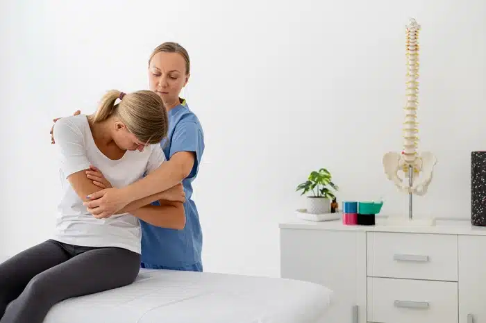 Chiropractor guiding patient through rehabilitative exercises for recover