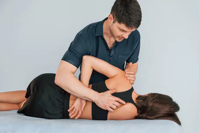 female patient getting chiropractic adjustment along with her rehabilitation program | Benefits of Chiropractic Manipulation