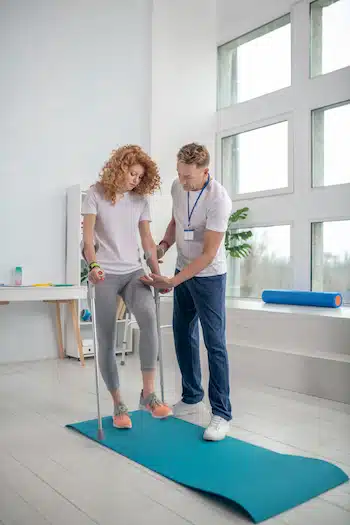 woman with leg injury from car accident undergoing physical rehabilitation to restore ability to walk | chiropractor after a car accident