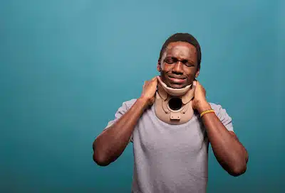 man with whiplash after a car accident holding his neck brace